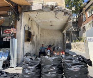 Depremde duvarları yıkılan iş yerinde kömür satmaya devam ediyor